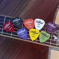 Set of colorful Alice guitar picks on a guitar neck